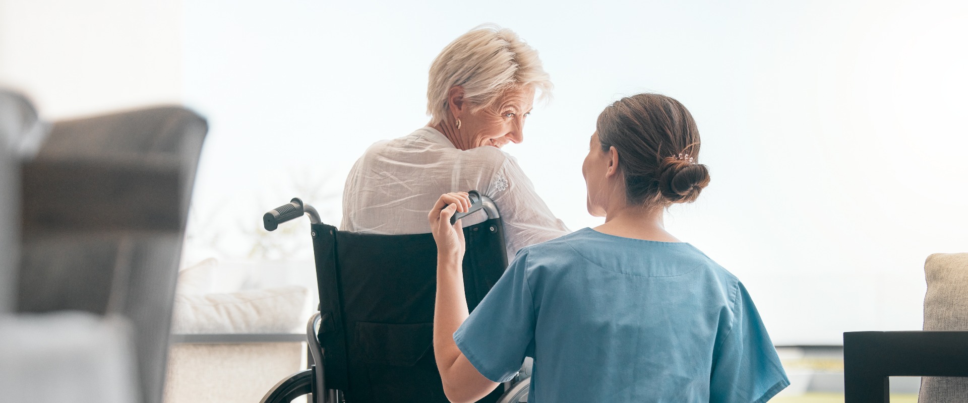 Alte Frau im Rollstuhl, Pflege oder Betreuerin im Gespräch für die Gesundheitsversorgung und Unterstützung im Pflegeheim. 